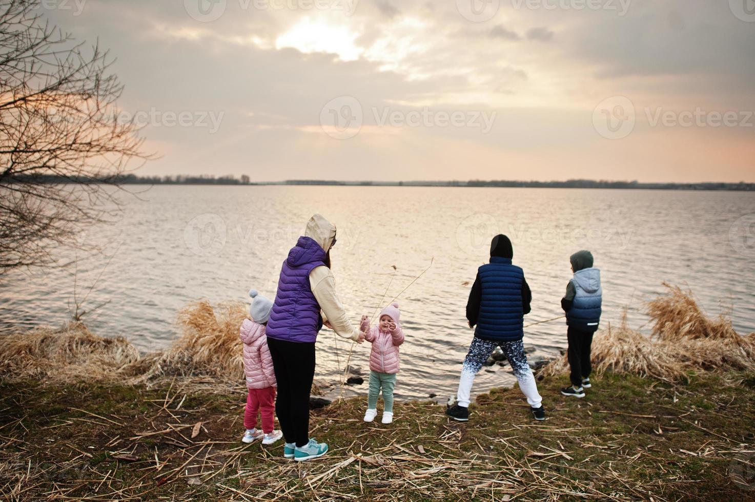 mamma med barn på stranden av sjön. foto