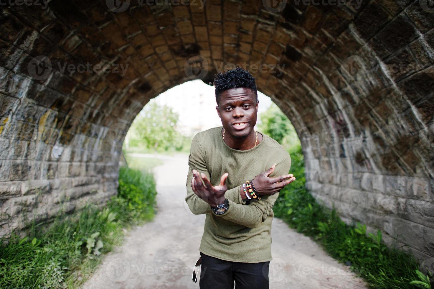 stilig ung afroamerikansk kille i lediga kläder poserar och går i tunneln. foto