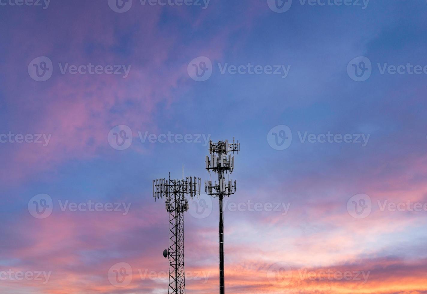 två mobiltelefontorn som tillhandahåller digital service till landsbygden vid solnedgången foto