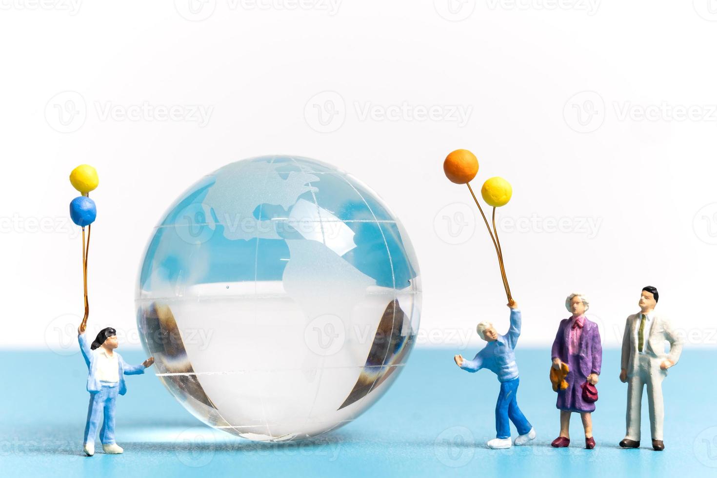 miniatyr människor unge håller ballong med kristallklot foto