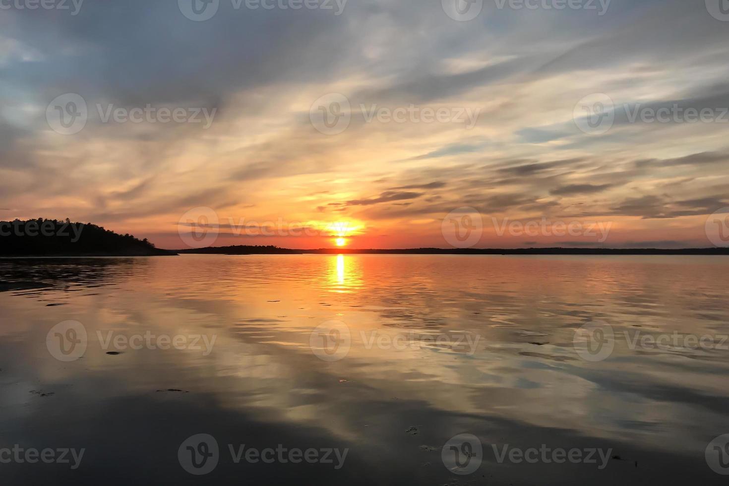 en vacker solnedgång över en sjö i den svenska sommaren foto