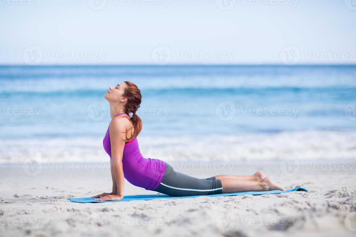 brunett gör yoga på träningsmatta foto