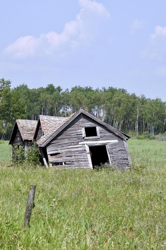 en övergiven gårdsbyggnad håller sakta på att kollapsa foto