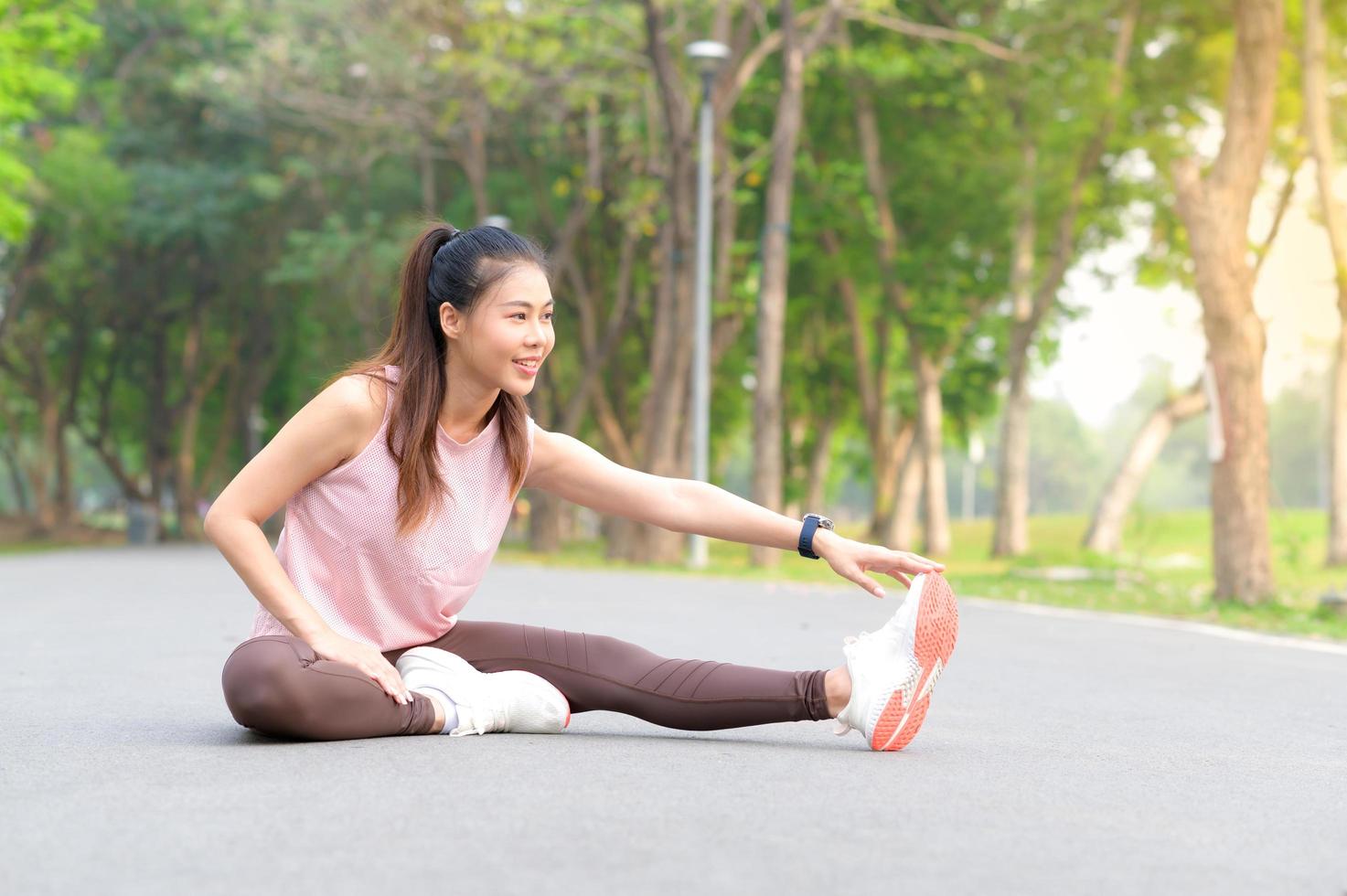 vackra asiatiska kvinnor tränar i parken varje morgon, det är en livsstil för avkoppling och god hälsa för kroppen foto