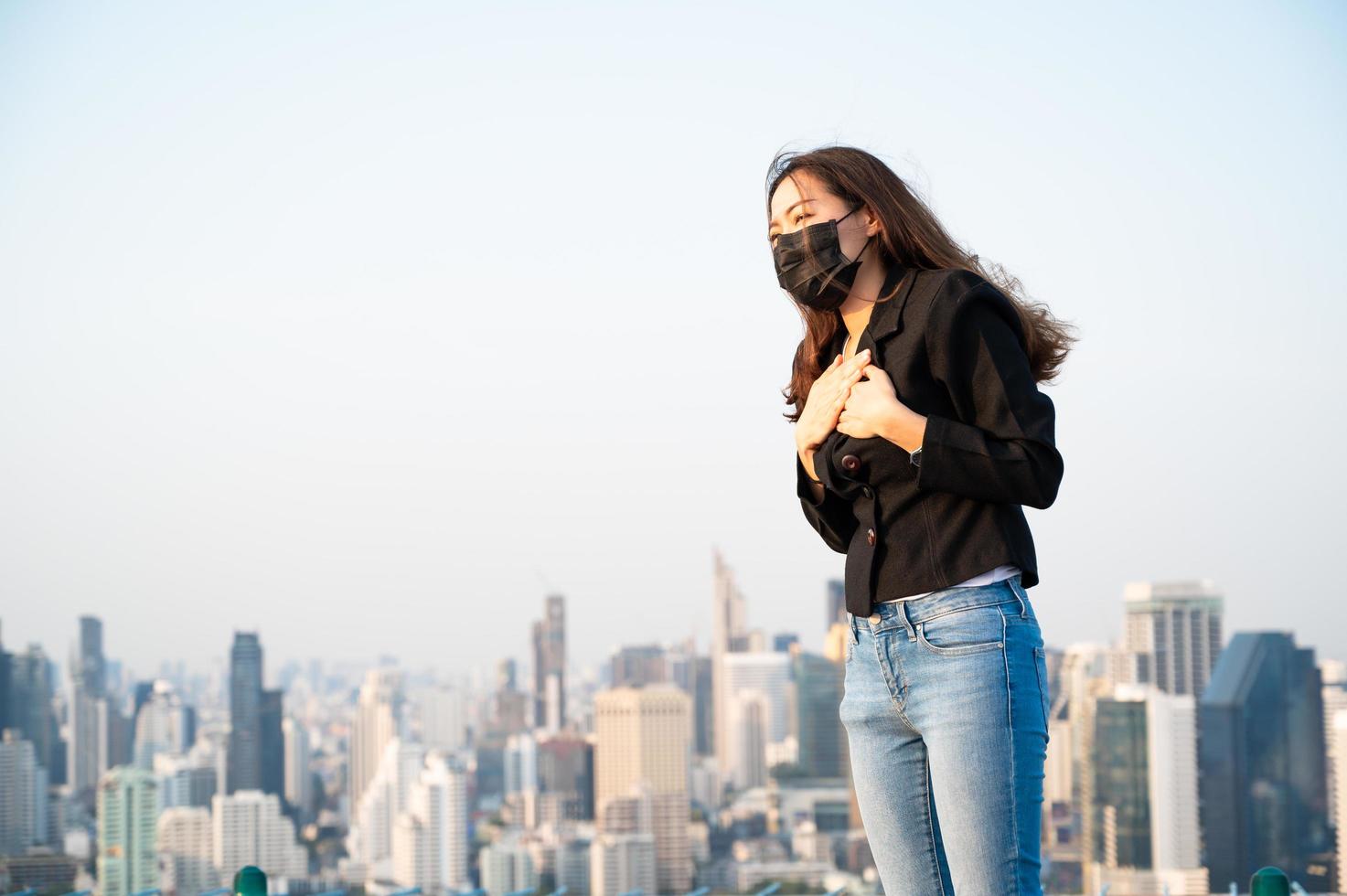 Asiatiska affärskvinnor måste använda en mask för att täcka ansiktet för att förhindra förorening från damm foto
