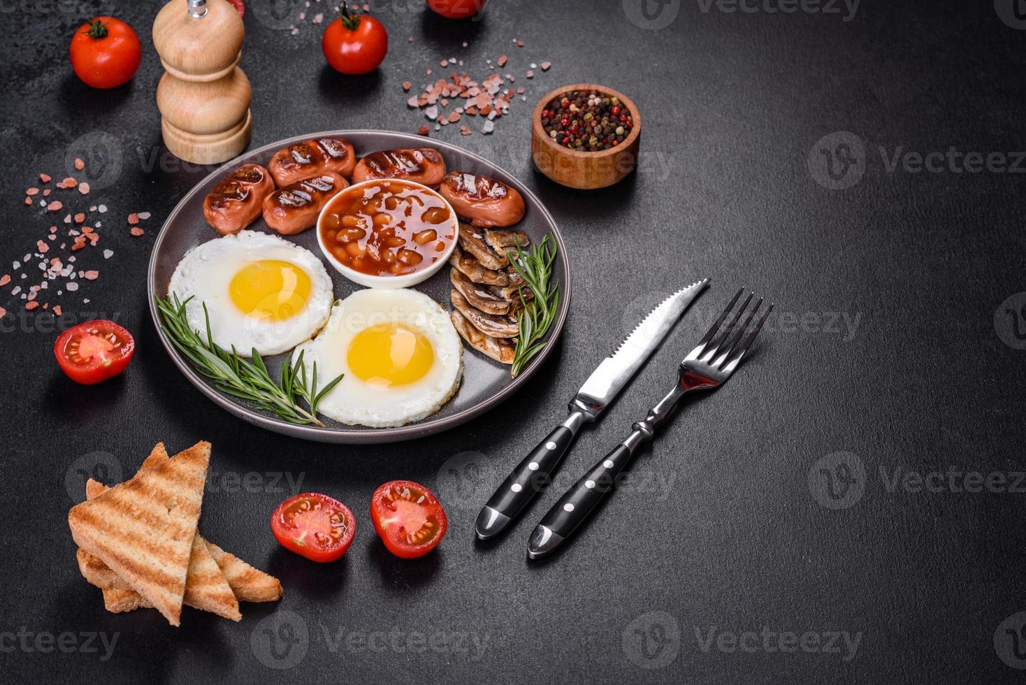 komplett engelsk frukost med bönor, stekta ägg, rostade korvar, tomater och svamp foto