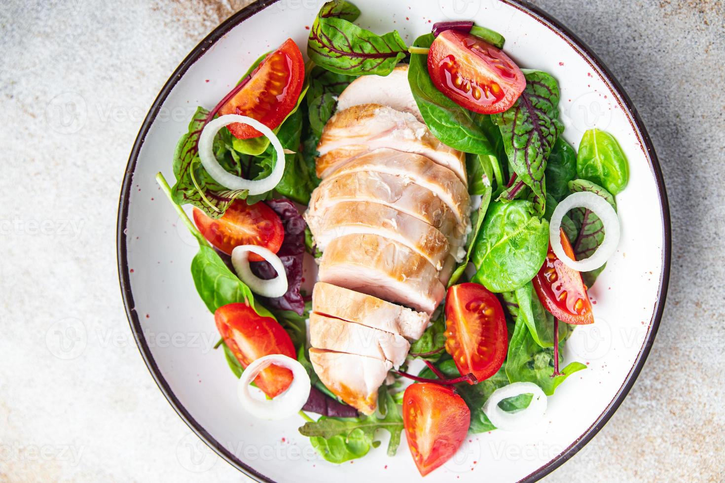 kycklingsallad grönsakstomat, kycklingbröst, lök, gröna blandningsblad sallad färsk måltid mat mellanmål på bordet foto