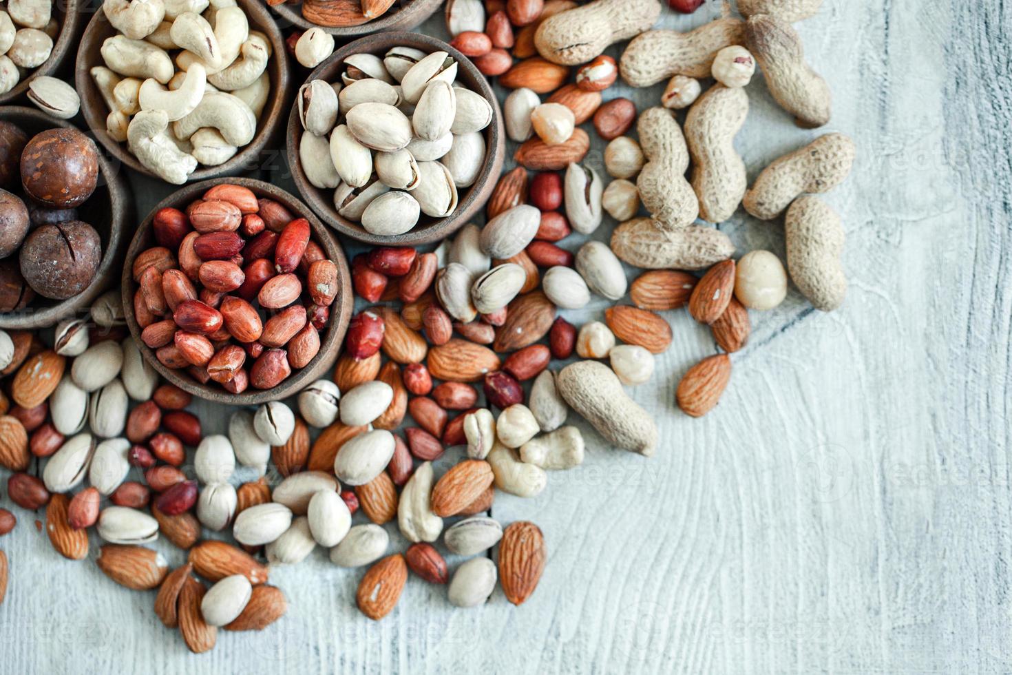 diverse nötter för en bakgrund mandel, valnöt, cashew, pistagenötter, hasselnötter, jordnötter, macadamia samling av olika sorter av nötter. sammansättning med torkad frukt hälsosam mat. organisk. foto