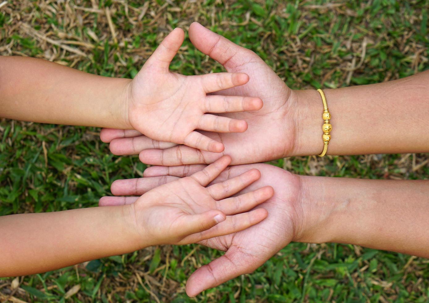 mammas hand håller en liten flickas hand på bokehbakgrund. kärlek och familj koncept. foto