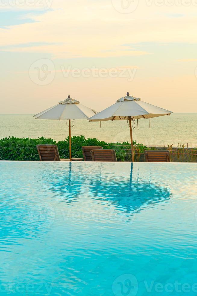 paraply med säng pool runt pool med havet havet bakgrund foto