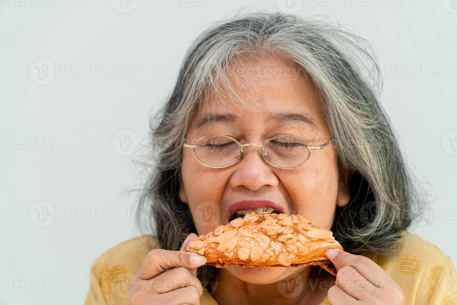 glada asiatiska äldre kvinnor njuter av att äta paj foto