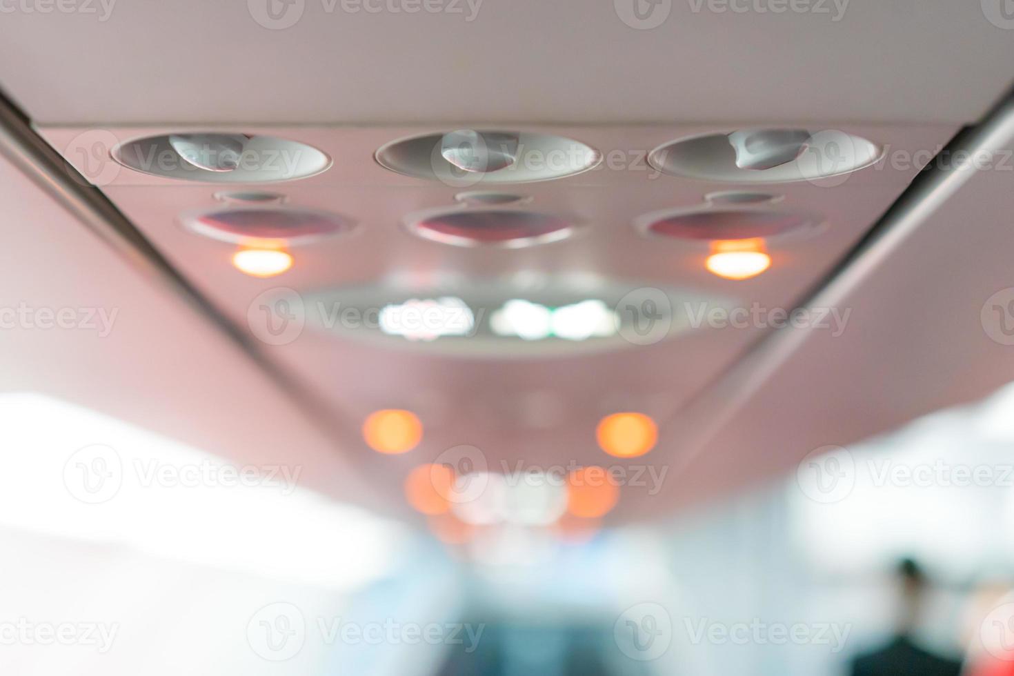 närbild flygplan konsol panel lampa, ljus, behöver hjälp knapp, luftkonditionering, sefty bälte och ingen rökning belysning skylt. foto
