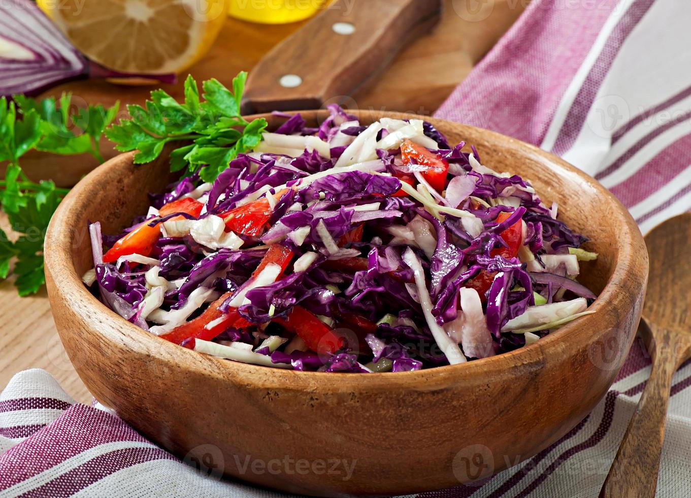 sallad av röd och vitkål och söt röd paprika, kryddad med citronsaft och olivolja i träskål foto