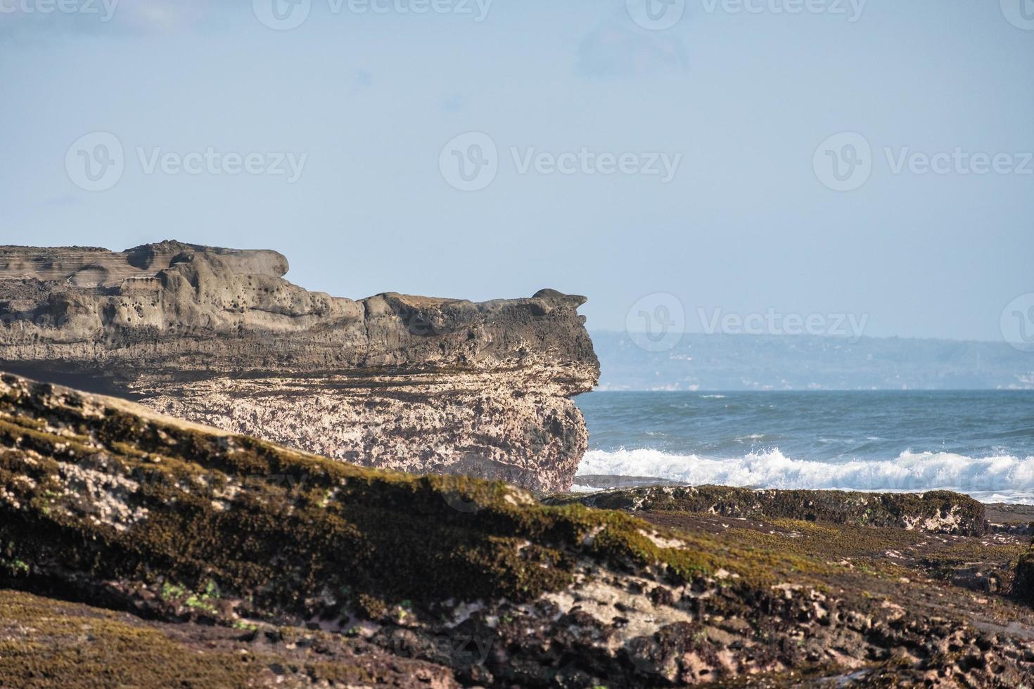 sten på kusten med våg foto