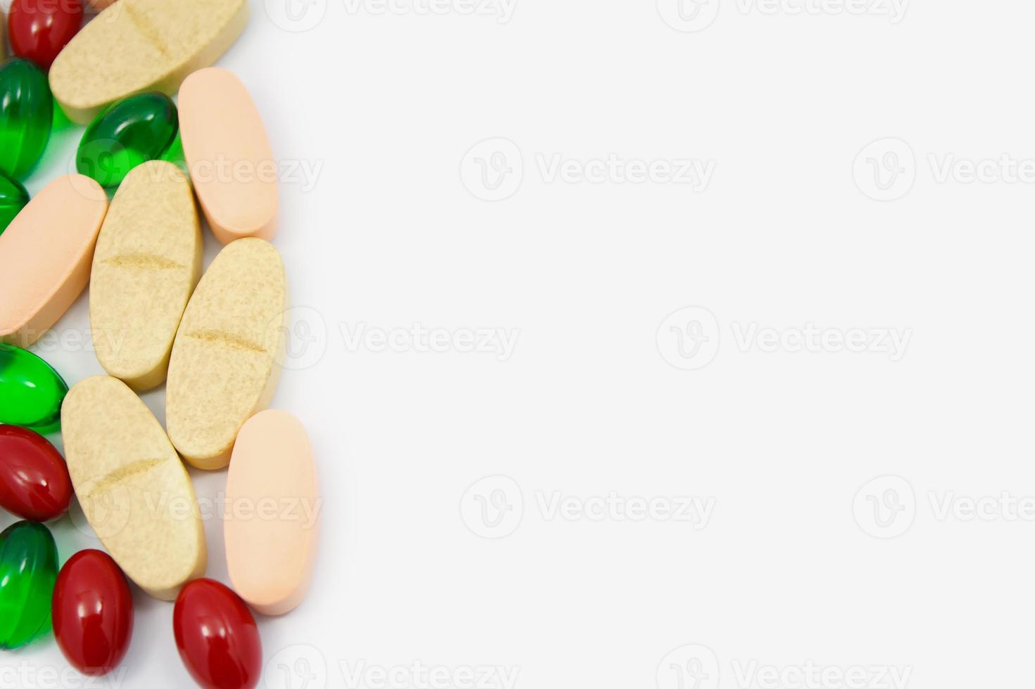 färgade piller, tabletter och kapslar på en vit bakgrund foto