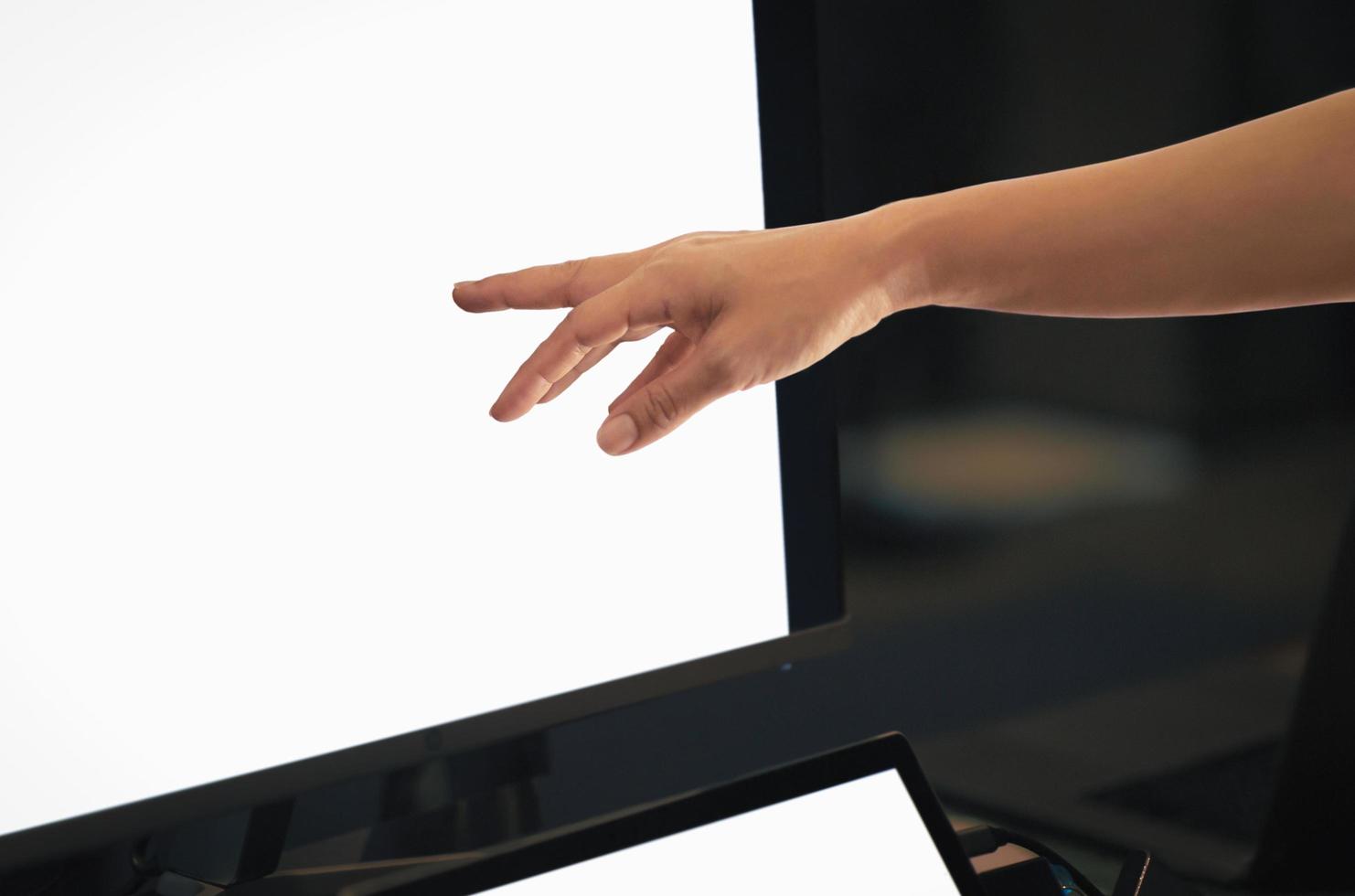 kvinna som arbetar på datorn med handen pekar på skrivbordsskärmen. foto