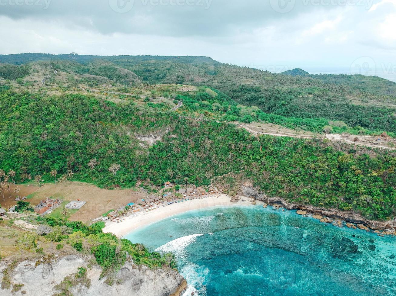 antenn drönare ovanifrån av korallstranden och blå havsvågor i nusa penida, bali, Indonesien. översikt över klippiga kusten och vikar foto