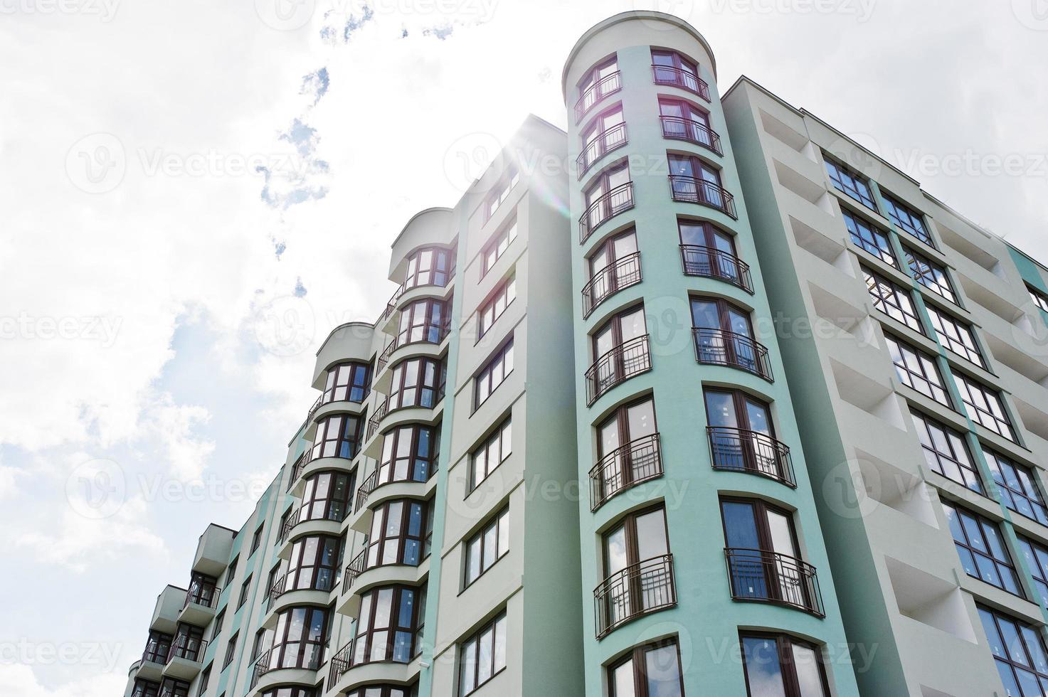 balkong med nya moderna turkosa flervåningsbostadshus i bostadsområde på solig blå himmel. foto