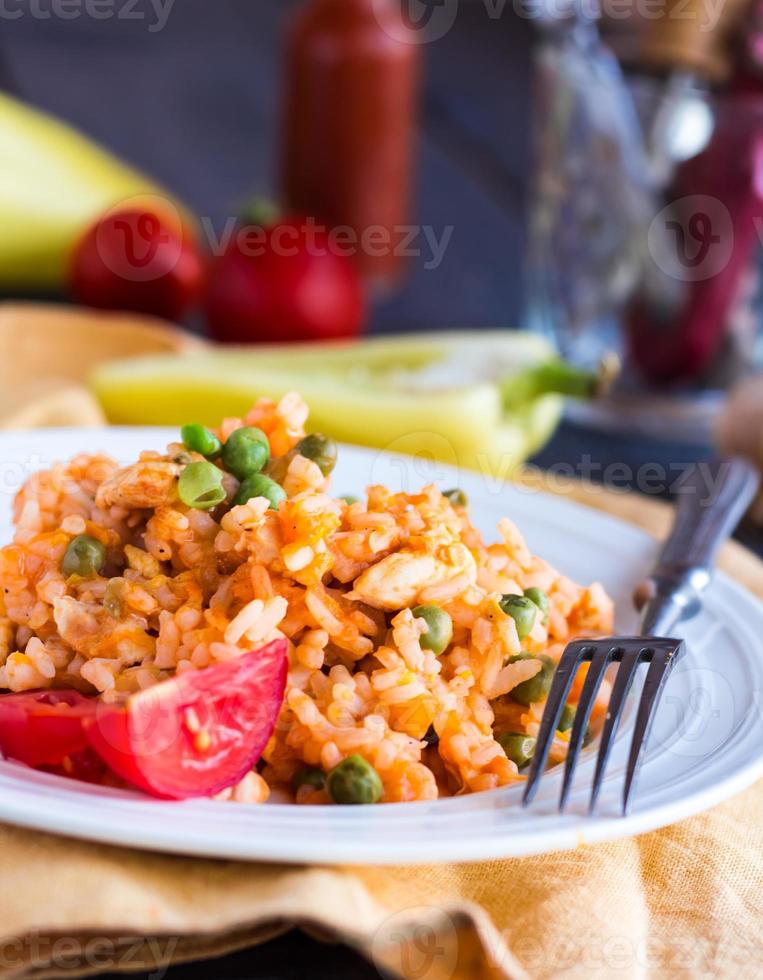 risotto med kyckling och grönsaker på en tallrik med gaffel foto