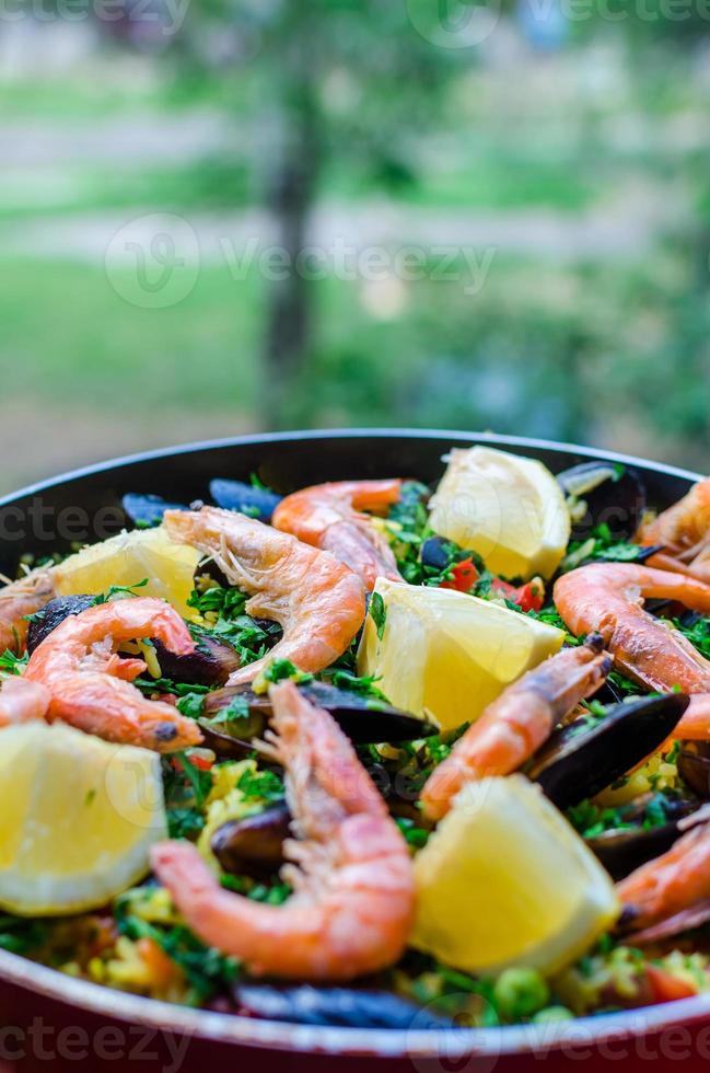 närbild klassisk skaldjur paella med musslor, räkor och grönsaker foto