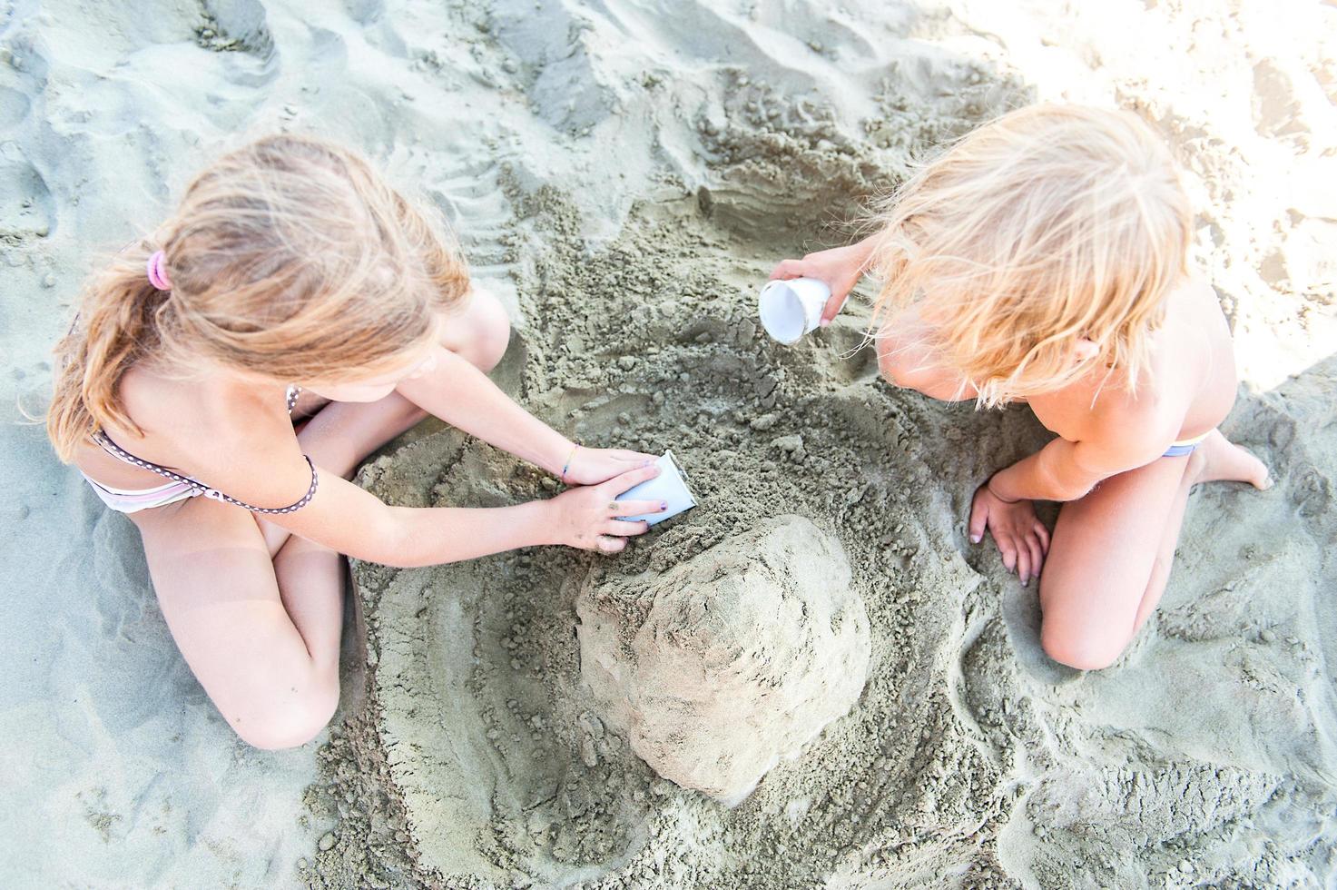 barn som leker på stranden med sand foto