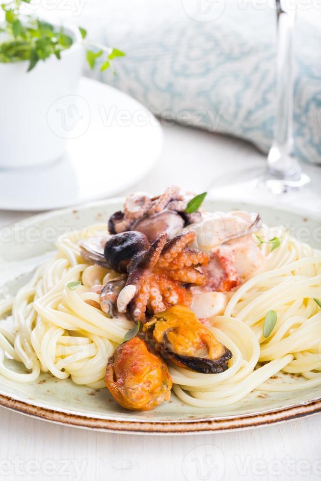 skaldjurspaghetti med räkor, kammusslor, musslor, bläckfisk och tomatsås foto