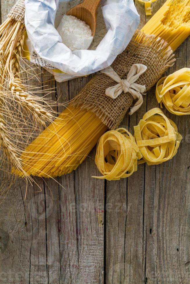 pasta och vete på rustik träbakgrund foto