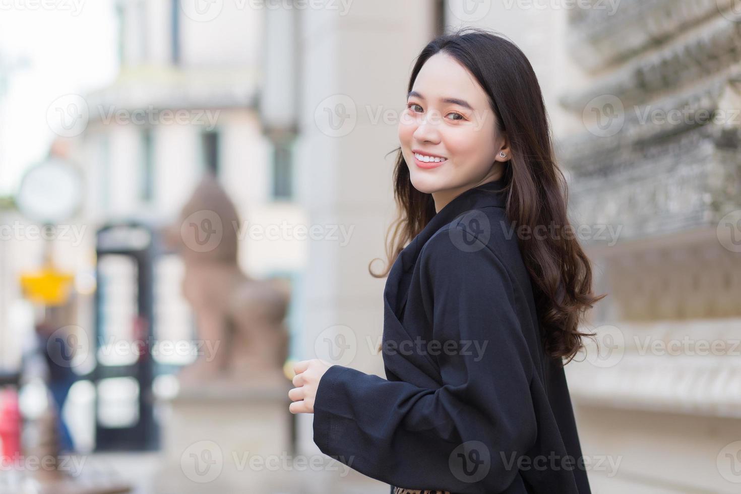 vackra asiatiska flickor ler lyckligt promenader i staden. foto