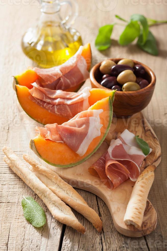 cantaloupemelon med prosciutto grissini oliver. italiensk appeti foto