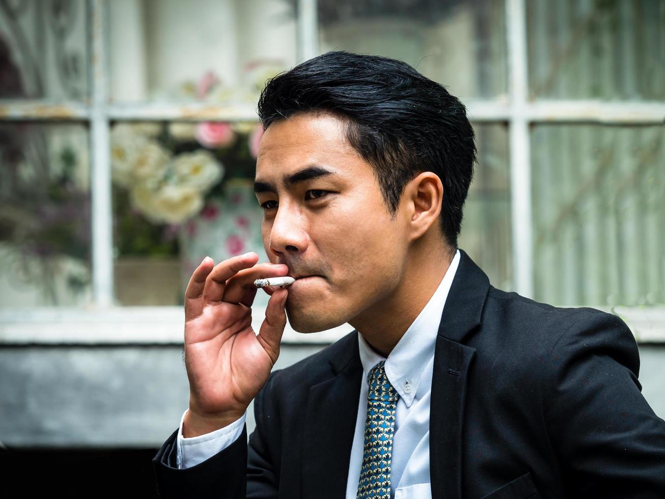 ung affärsman röker och tänker på affärsfrågor foto