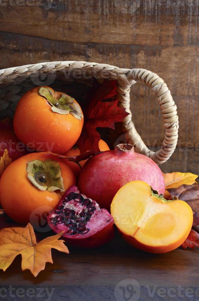 korg med färska persimon och granatäpplen foto