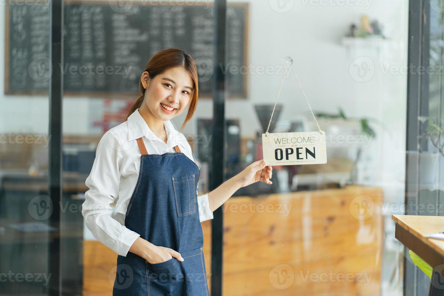 leende servitris eller café företagare entreprenör tittar på kameran foto