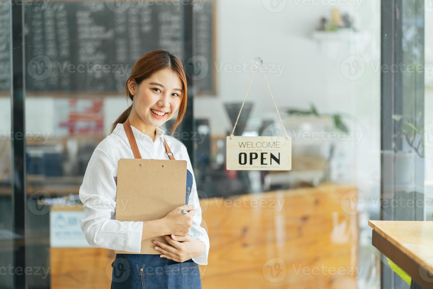 leende servitris eller café företagare entreprenör tittar på kameran foto