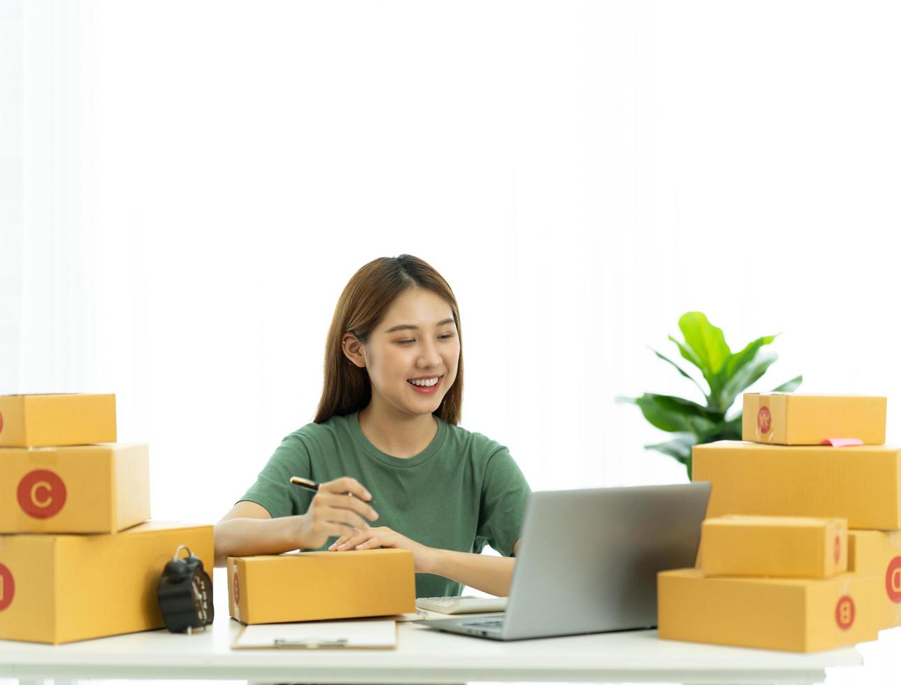 startar småföretag SME-ägare kvinnliga entreprenörer kollar onlinebeställningar för att förbereda sig på att packa lådorna, sälja till kunder, SM-affärsidéer online. foto