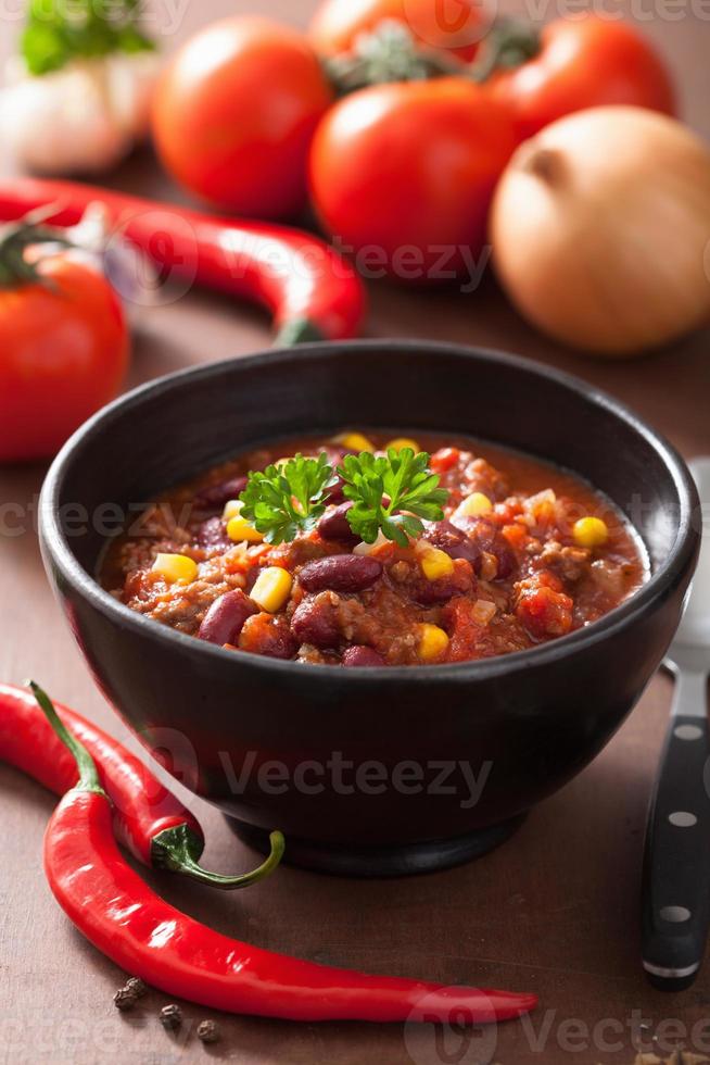 mexikansk chili con carne i svart platta med ingredienser foto
