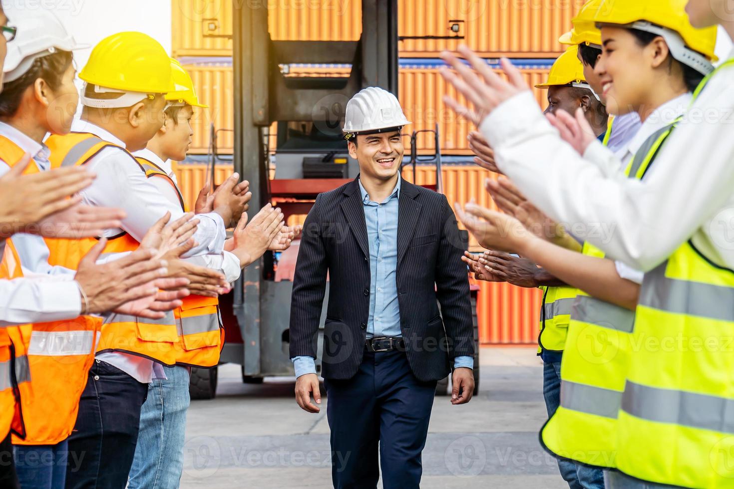 professionella ingenjörs- och arbetarteam gratulerade till framgången genom att applådera sin jublande ledare efter att byggprojektet slutförts med framgång. teknisk tung industrikoncept foto