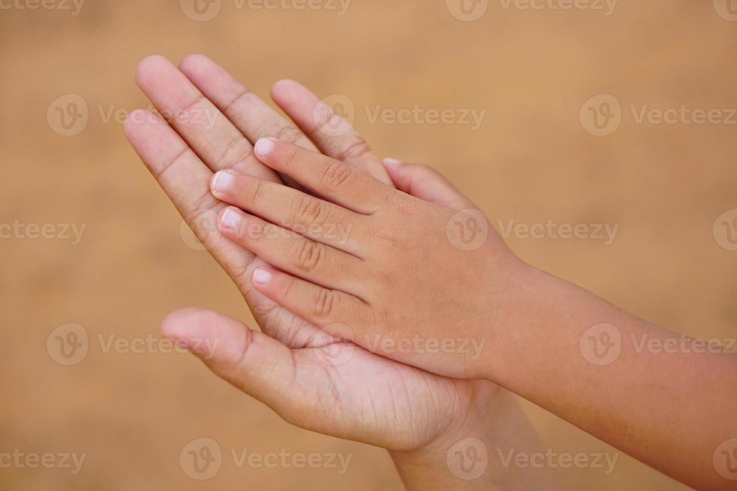 mor och barn håller varandra i hand för att ta emot något foto