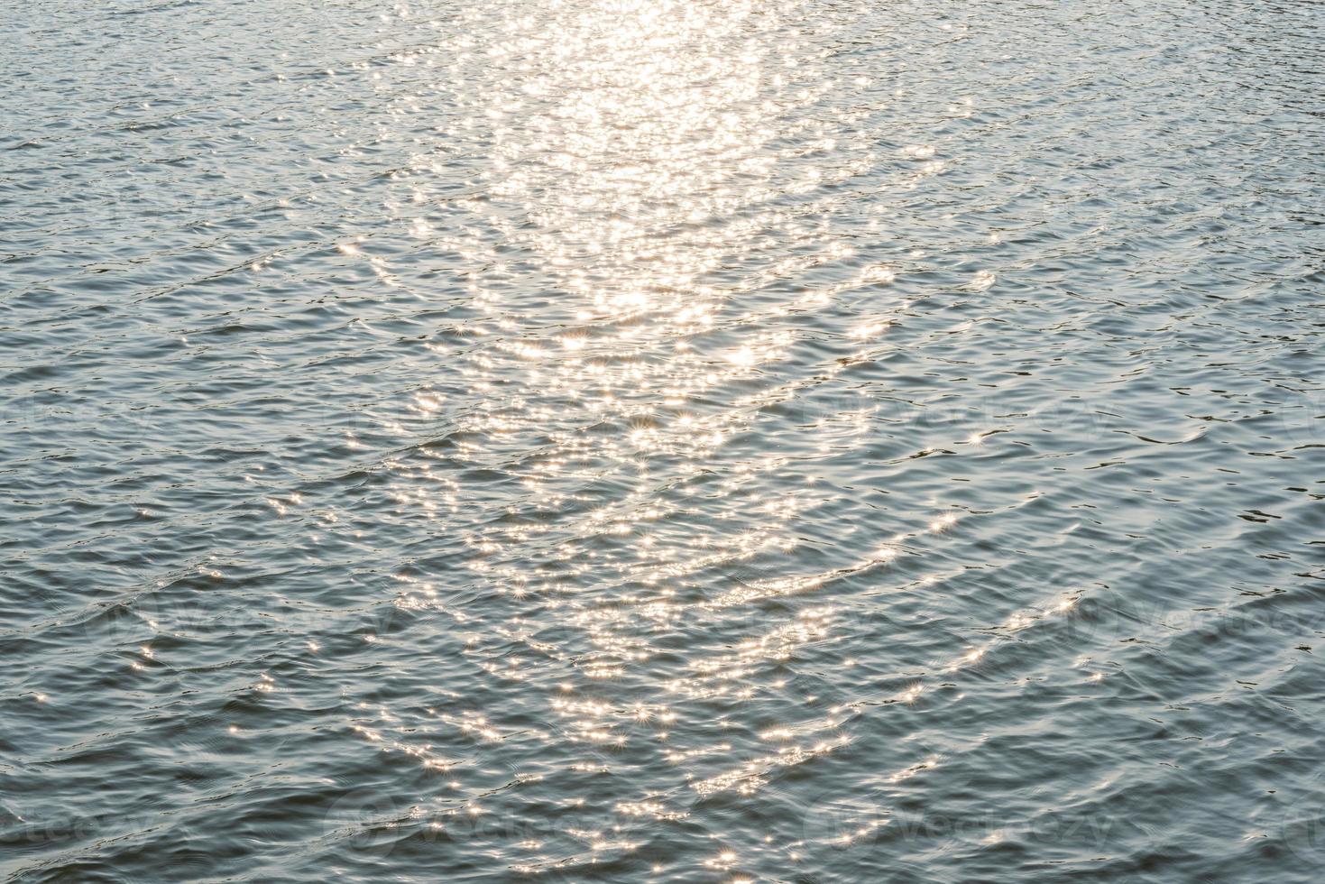 solljus som reflekteras på vattenytan foto