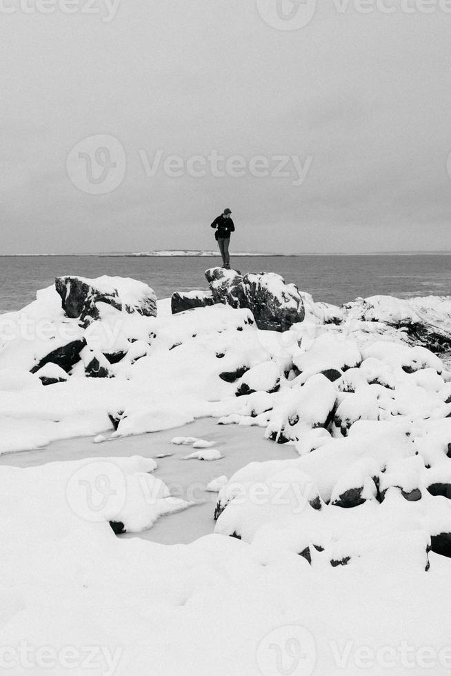 peron på en kuperad och snöig strand foto