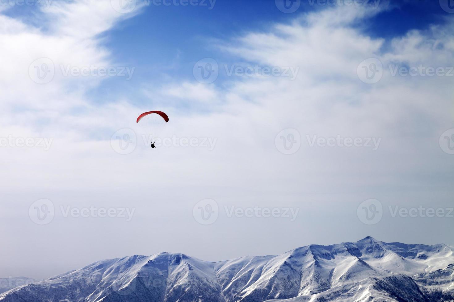 paraglider silhuett av berg i blåsig himmel foto