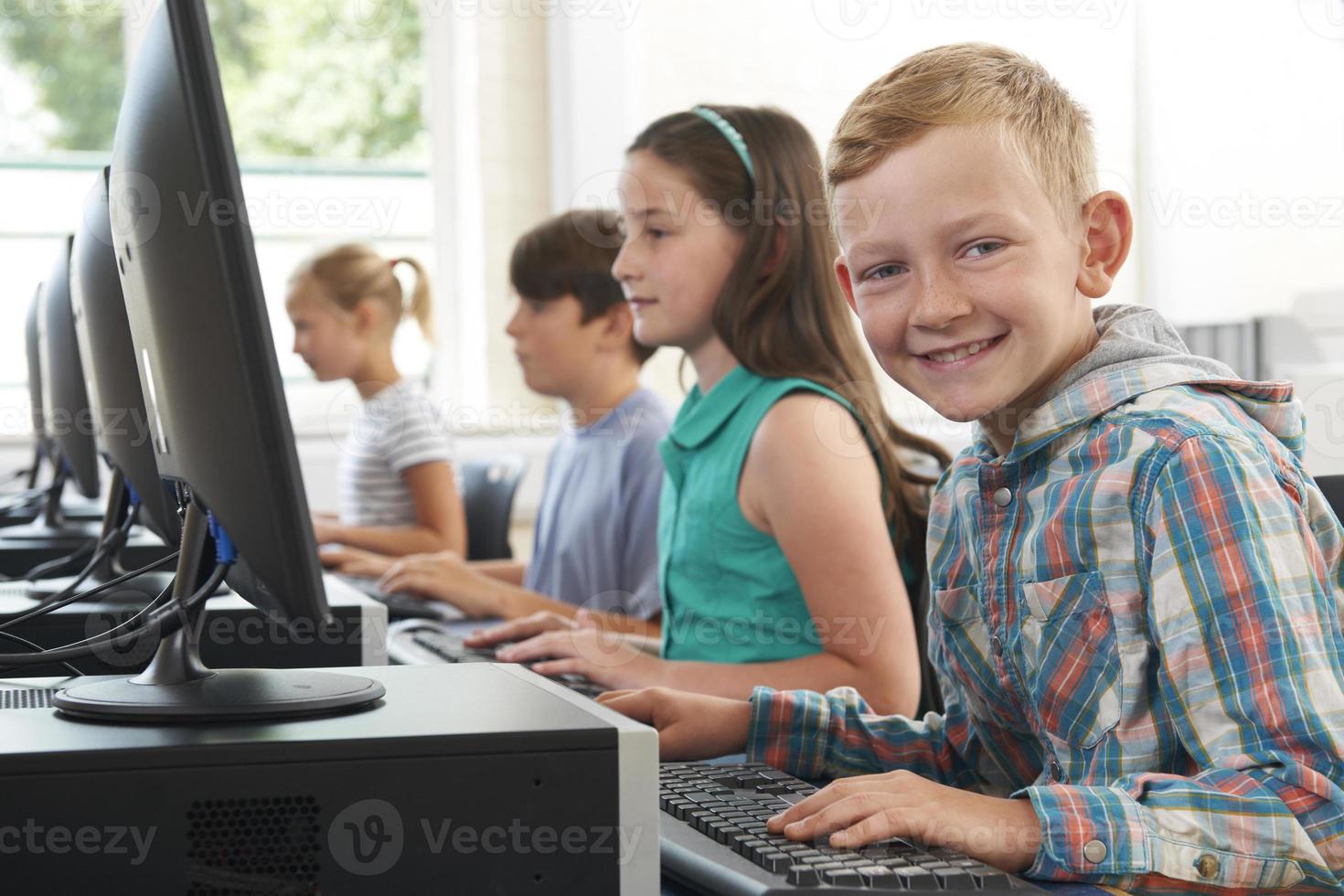 grupp grundskolebarn i datorklass foto