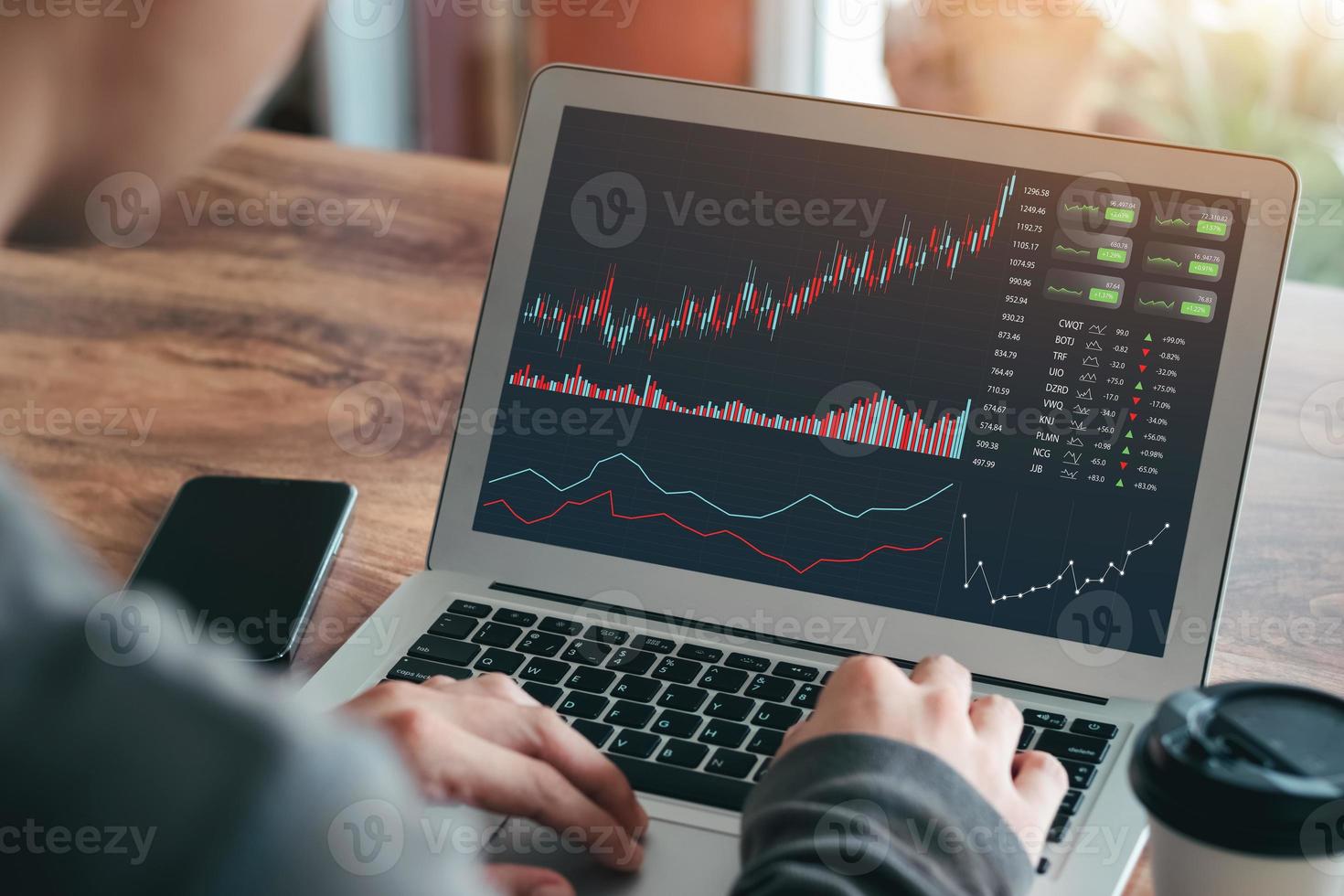 affärsmän arbetar med aktiemarknadsinvesteringar med bärbara datorer för att analysera handelsdata. stationär dator med börsdiagram på skärmen. finansiella aktiemarknaden. analysera data i kontorsbakgrund. foto