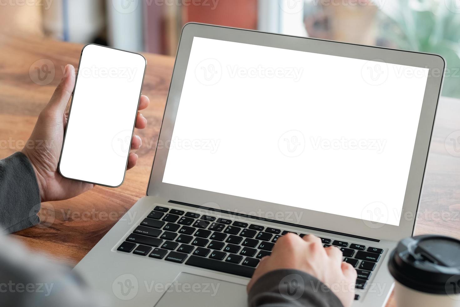 mockup kopia utrymme dator bärbar dator bärbar dator och smartphone koncept, man hand använder laptop på internet webbplatser på kontoret, balnk kopia skärm för ditt reklaminnehåll. foto