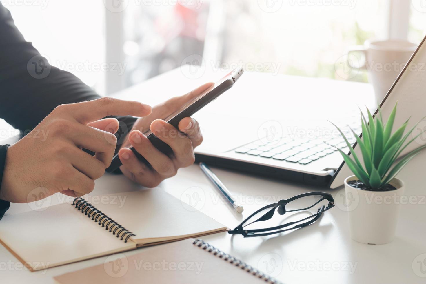 arbeta med mobiltelefon skriva dator mobil chatta laptop kontakta oss på arbetsplatser, planering idéer investerare internetsökning, idéer som kopplar samman människor. foto