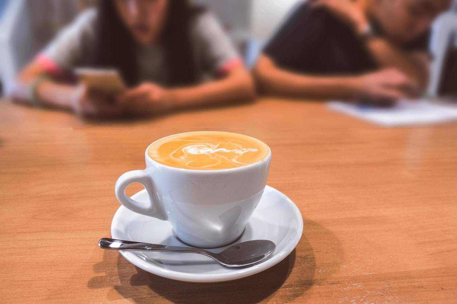 varm kaffe latte på ett träbord. foto