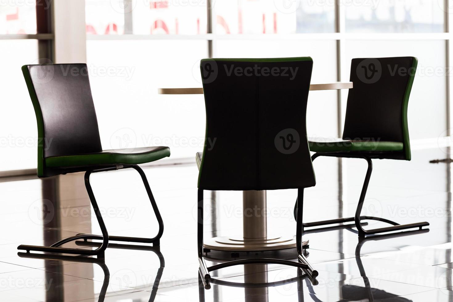 bakgrundsbelyst koncept av stolar och bord på kontoret foto