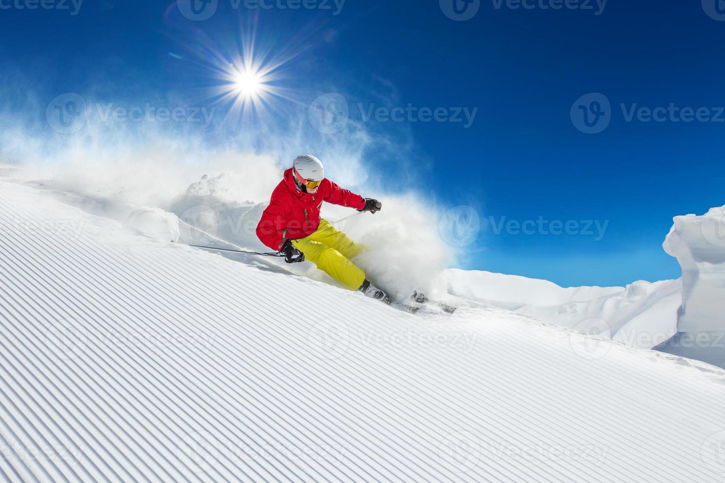 skidåkare skidåkning nedförsbacke i höga berg foto