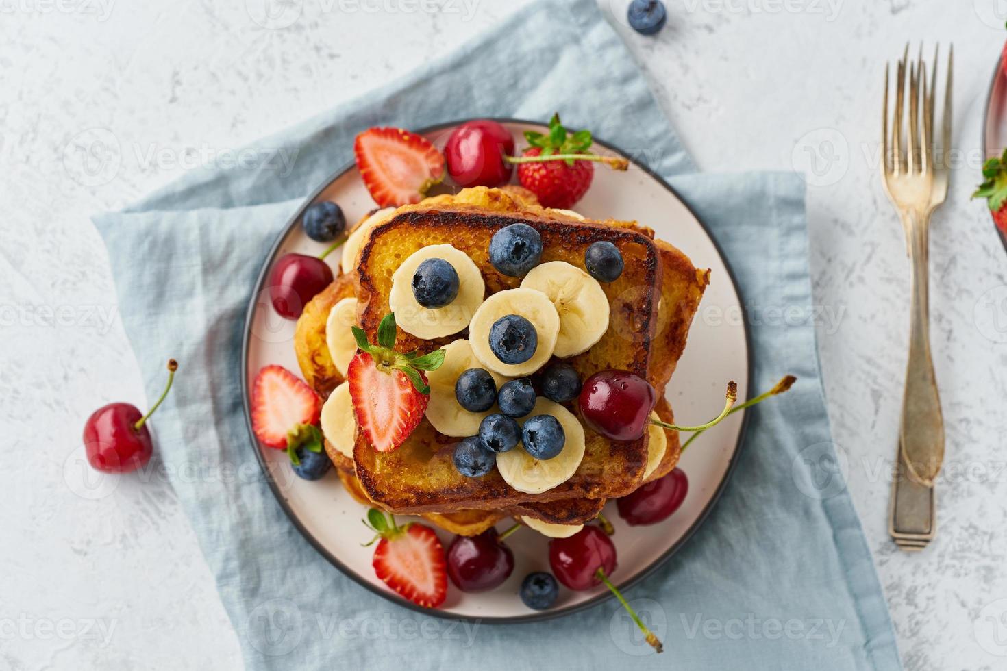 french toasts med bär och banan, brioche frukost, vit bakgrund, ovanifrån foto