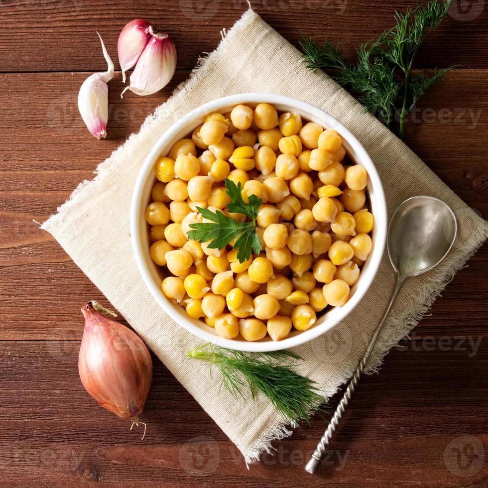 kokta kikärtor på skål på mörkt träbord. hälsosamt, vegetariskt foto