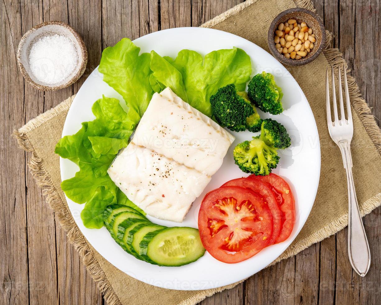 ångad torskfisk. paleo, keto, fodmap hälsosam kost med grönsaker foto